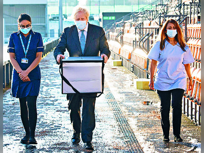 Boris Johnson helps to load doses of vaccine for mobile distribution. Reuters